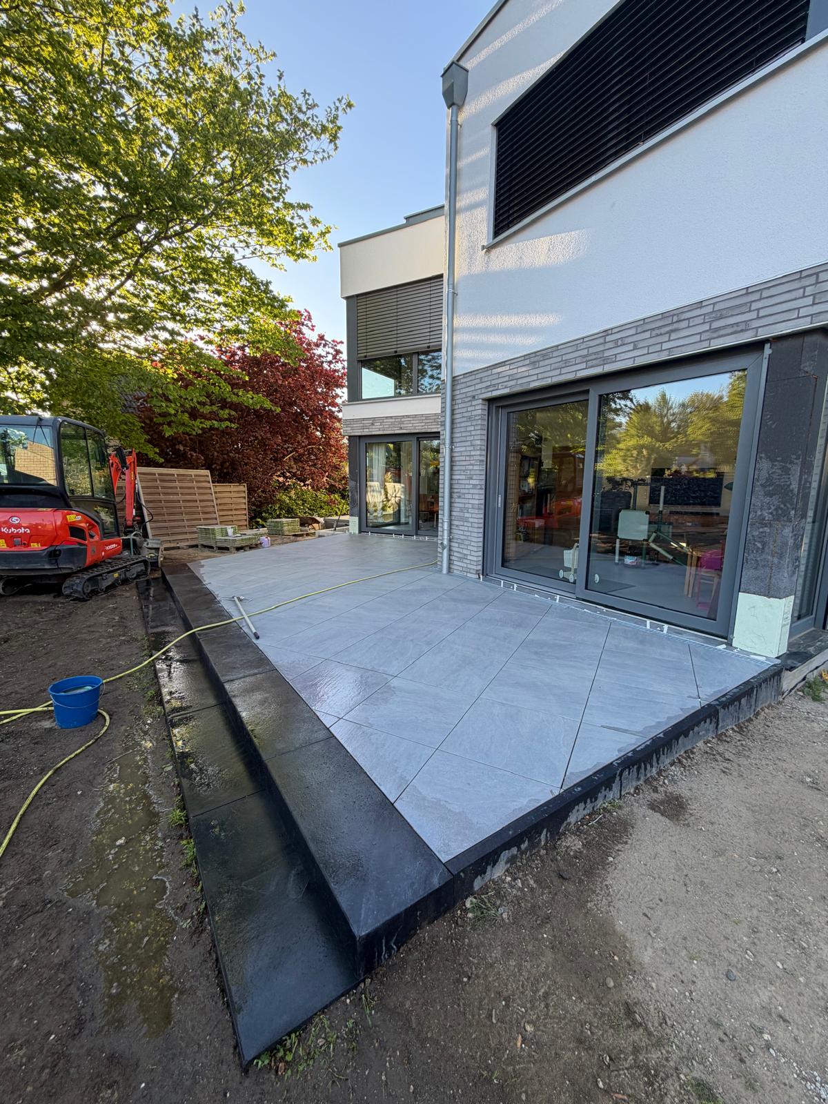 Terrasse mit anthrazit eingefassten Bodenplatten